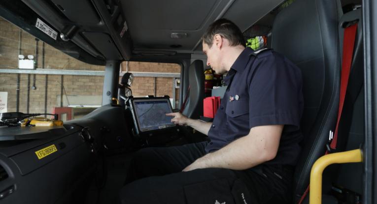 Image of firefighter using fire engine onboard computer 