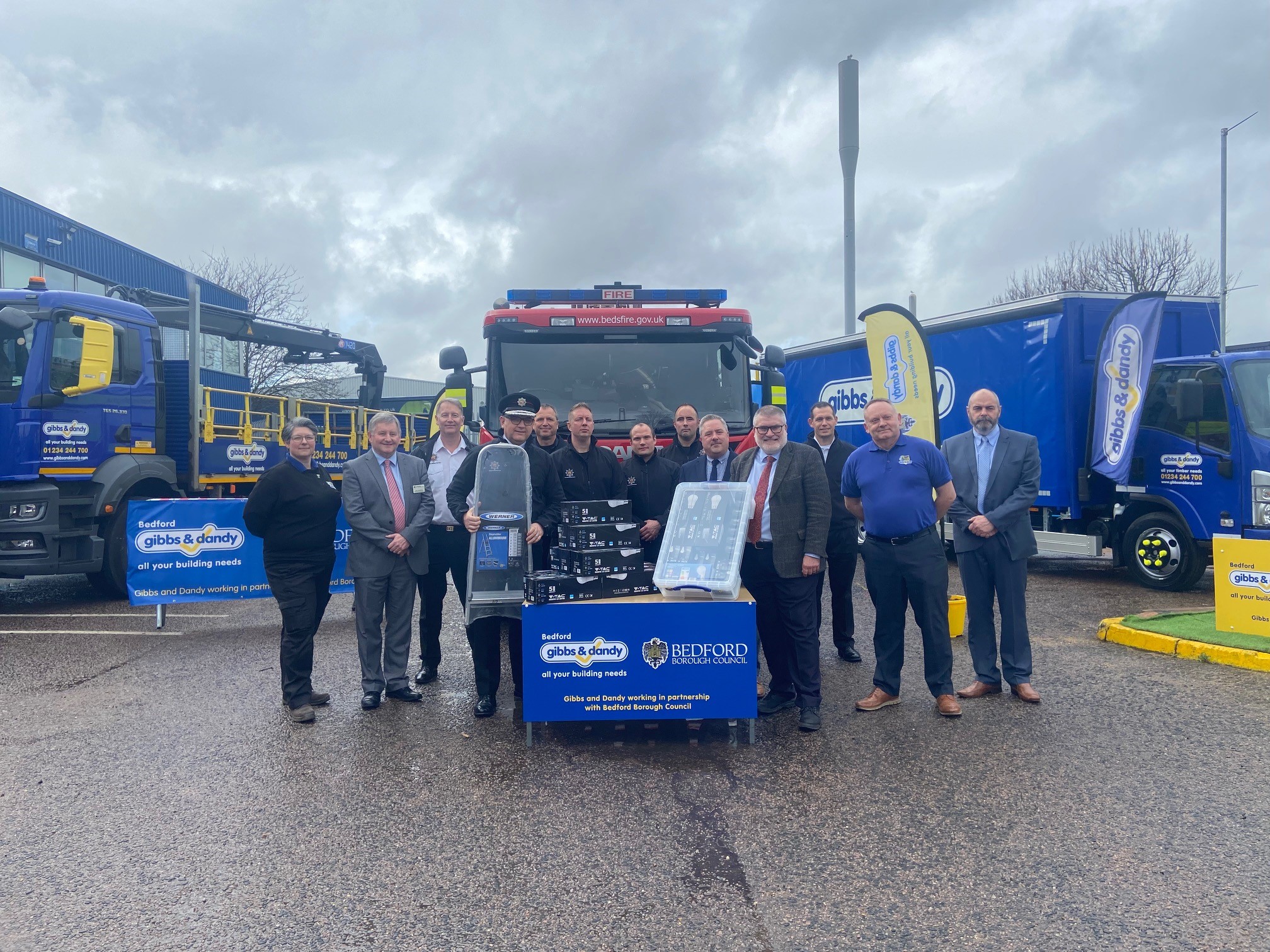 Photo shows the Mayor of Bedford Borough, Brand Director for Gibbs and Dandy and Chief Fire Officer Bedfordshire Fire and Rescue Service in front of a fire truck