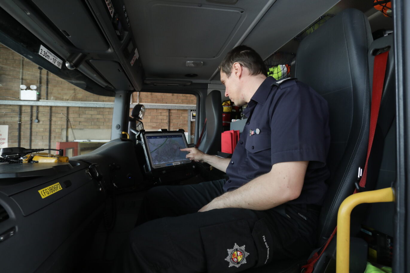Image of firefighter using fire engine onboard computer 