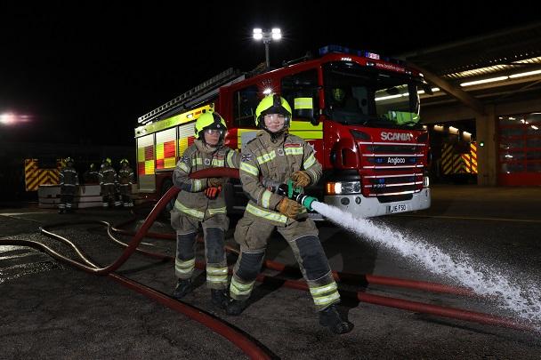 Firefighters holding hose