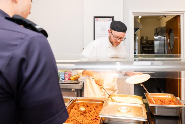 Cook at a hot plarte serving counter