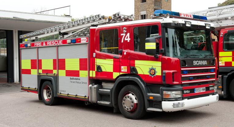 Photo of a fire engine parked outside a fire station