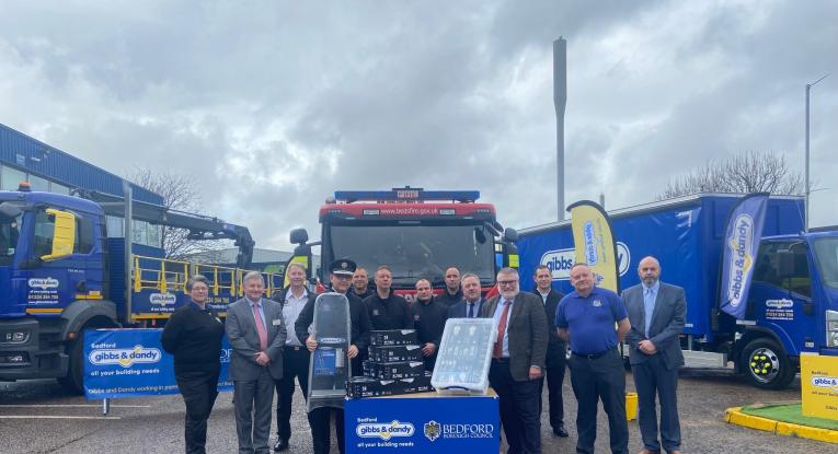 Photo shows the Mayor of Bedford Borough, Brand Director for Gibbs and Dandy and Chief Fire Officer Bedfordshire Fire and Rescue Service in front of a fire truck