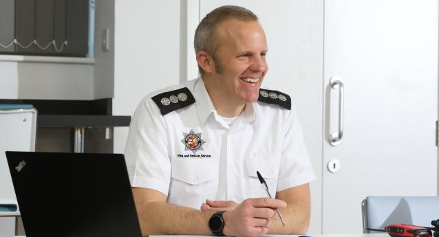 A BFRS colleague sat at a desk with a laptop